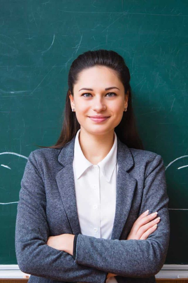 smiling young teacher near the board
